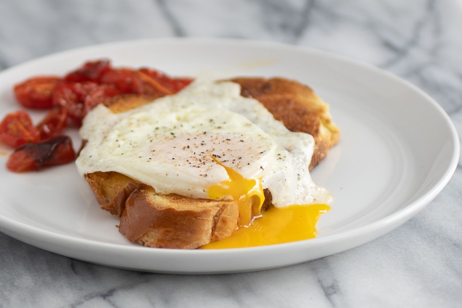 Egg over easy on a slice toast with the yolk oozing out