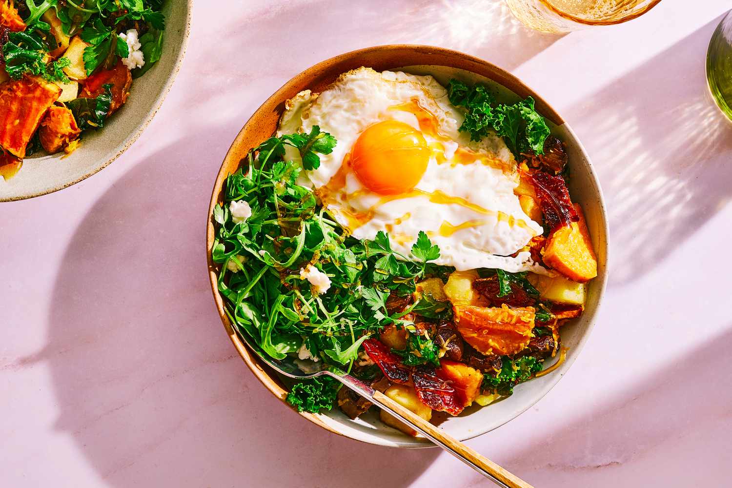 A bowl of First Watch's million dollar harvest hash topped with a fried egg and hot honey