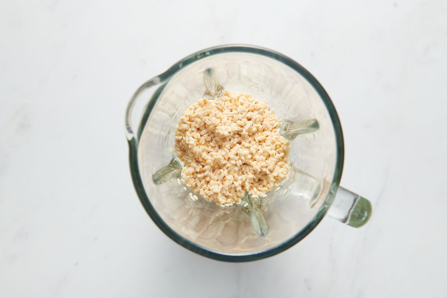 A blender pitcher with soaked urad dal and fenugreek seeds
