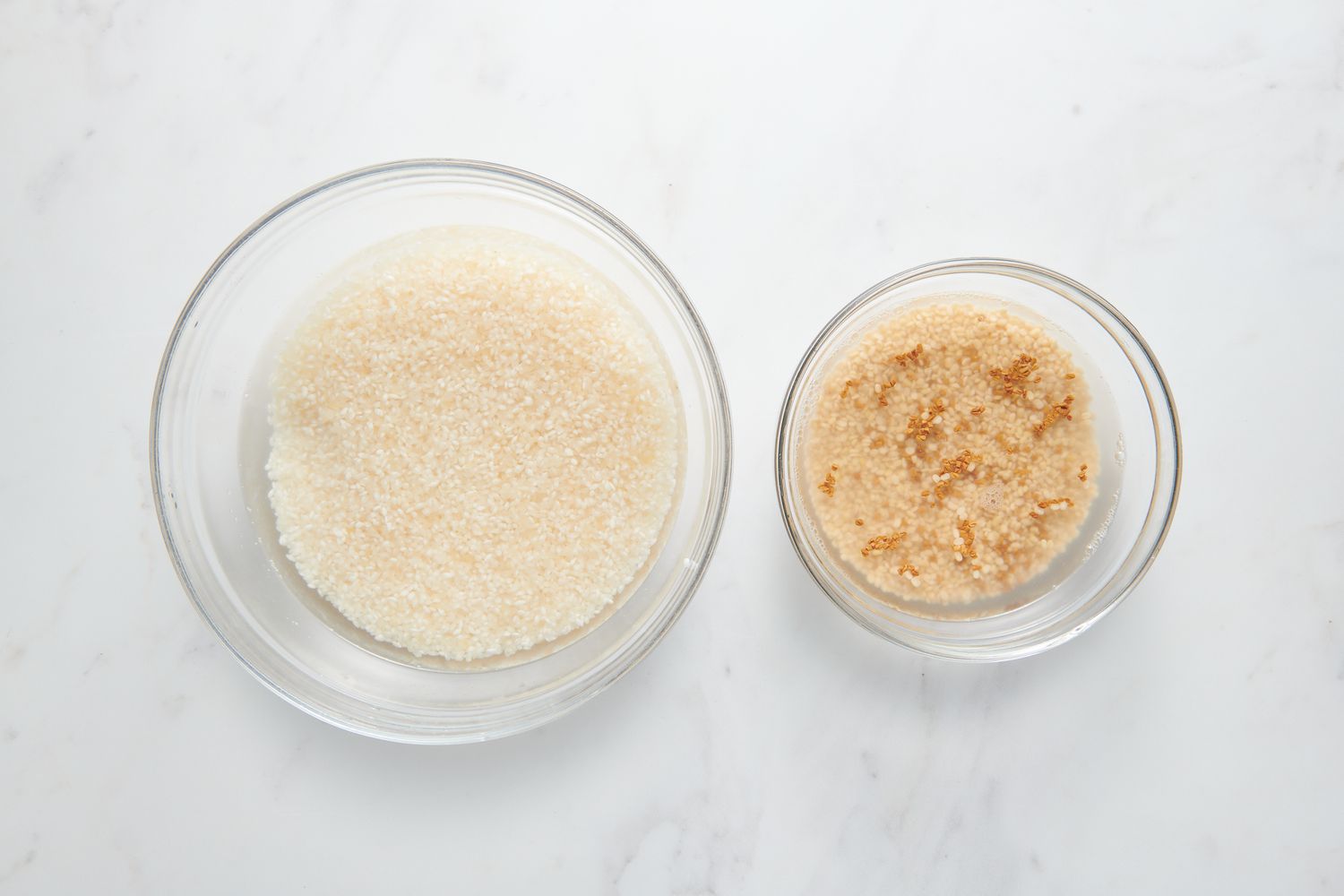 A bowl of Sona Masuri in water, and a bowl of urad dal and fenugreek in water