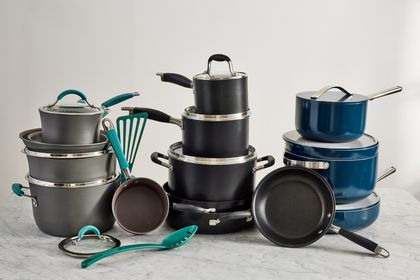 Several nonstick cookware sets displayed on a marbled surface