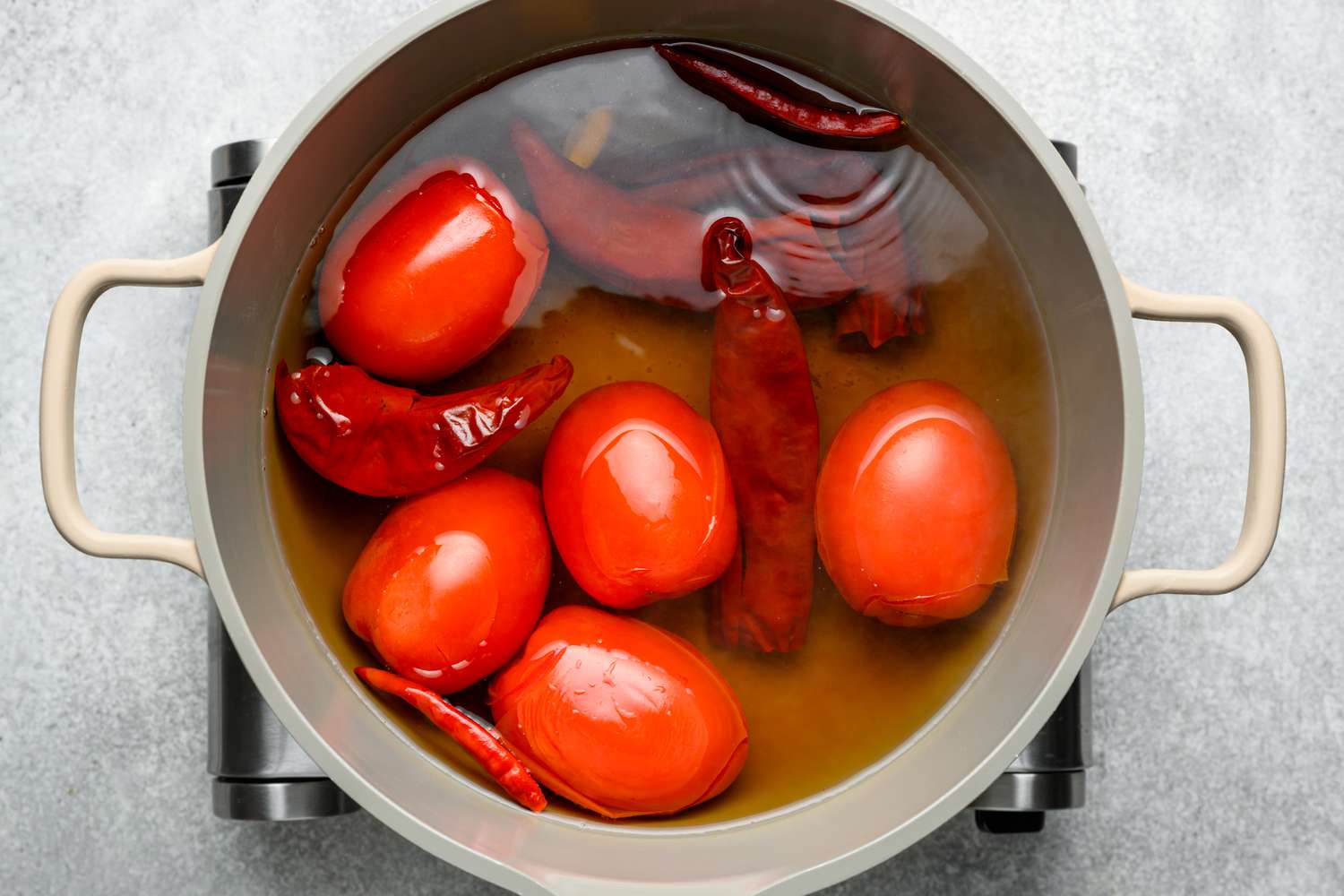 A pot of water with guallijo chiles, chile de arbol, Roma tomatoes, and garlic