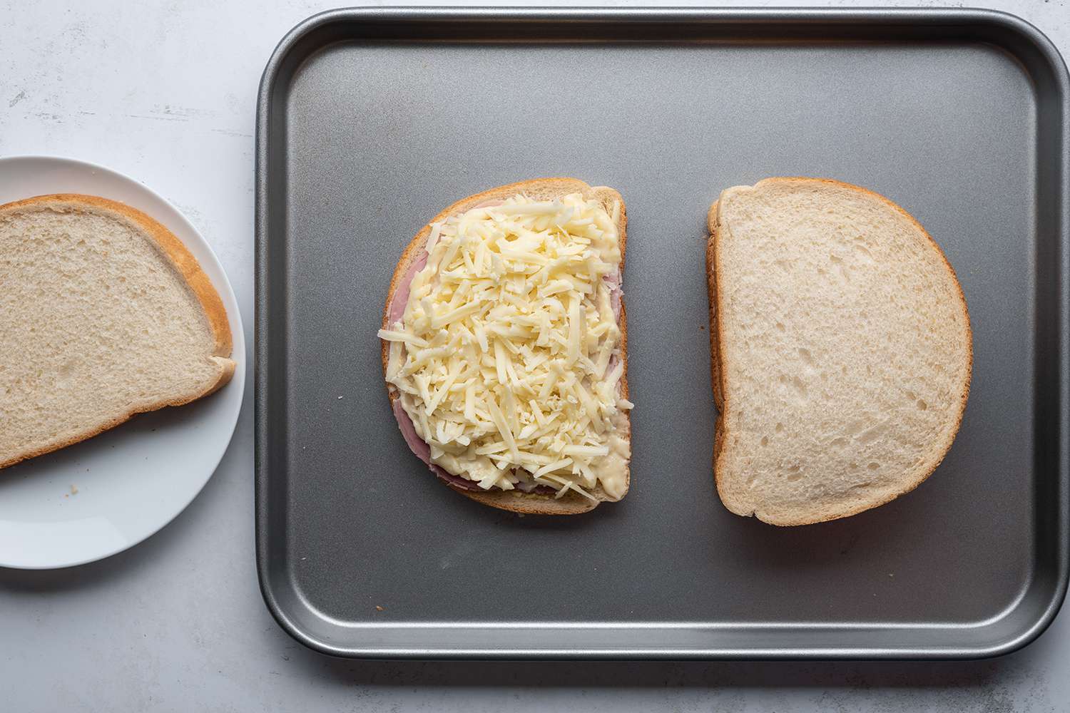 Cheese, bread and ham sandwiches on a sheet pan