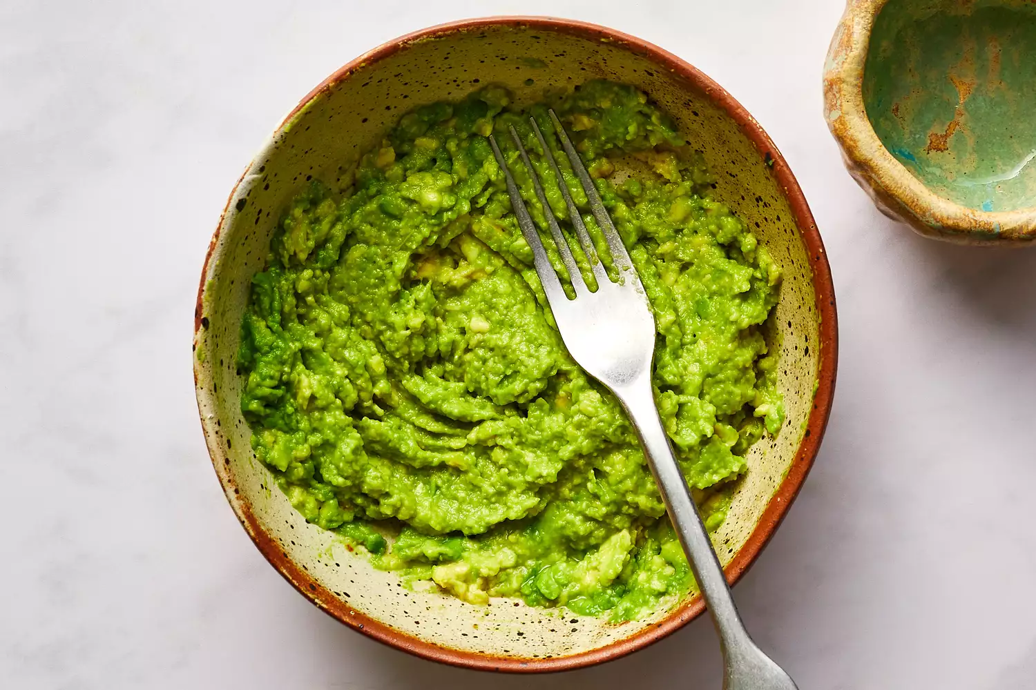 avocado mashed in bowl with a fork