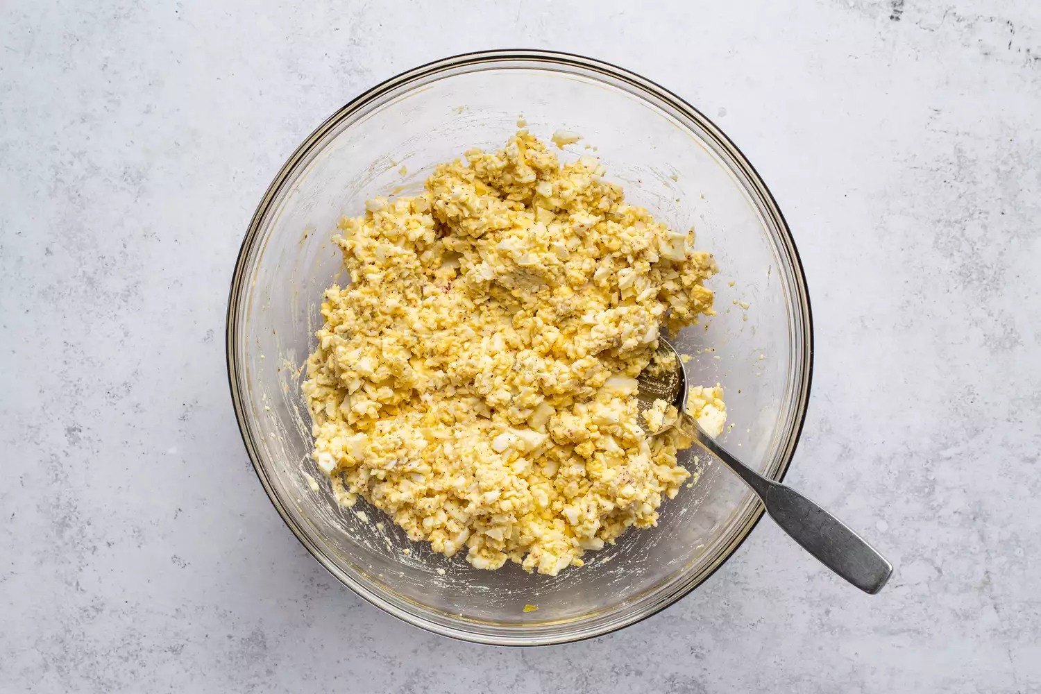 Salada clássica de ovo com relish em uma tigela, com uma colher