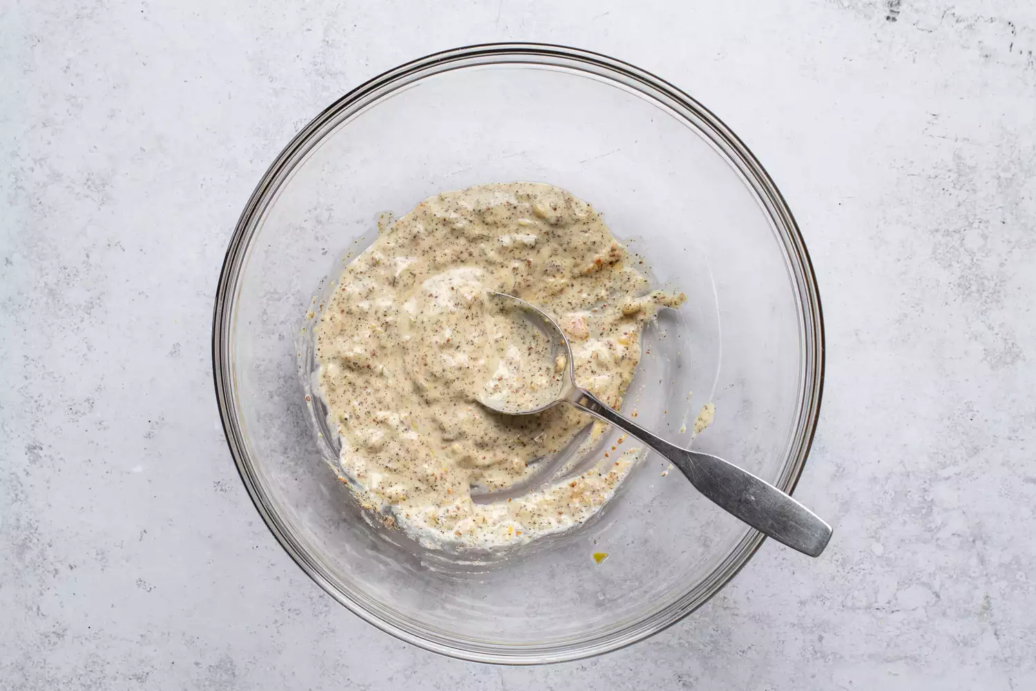 Maionese, relish, mostarda e sal e pimenta em uma tigela, com uma colher