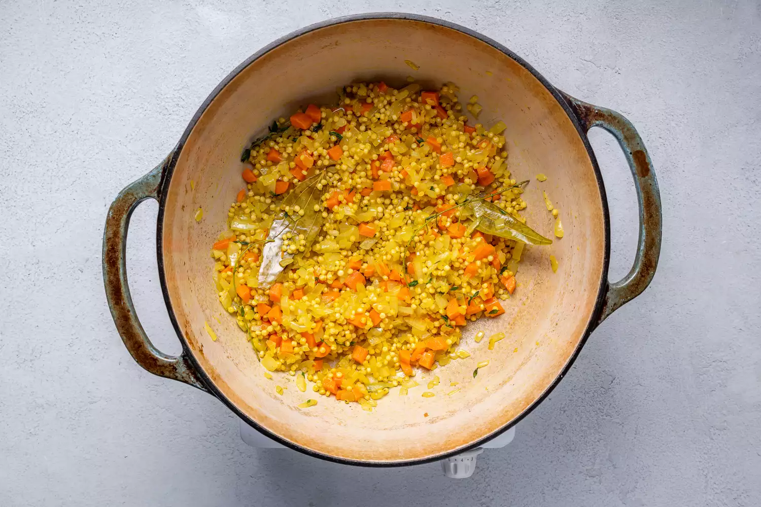 Folhas e talos de tomilho e massa adicionados à mistura de vegetais