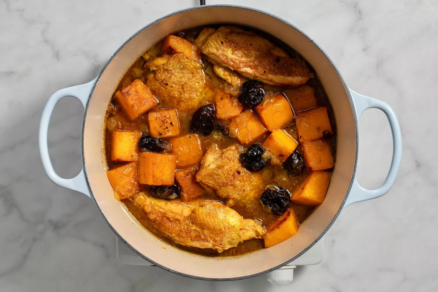 especiarias restantes, além da abóbora e ameixas adicionadas à panela com frango