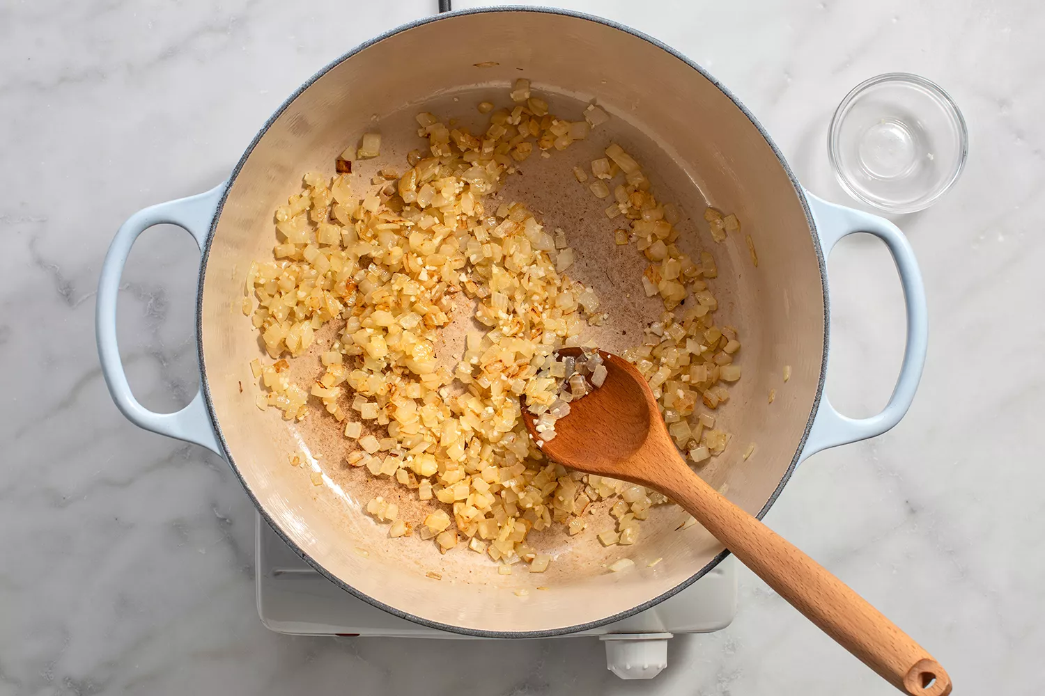 Cebola e alho cozinhando em uma panela