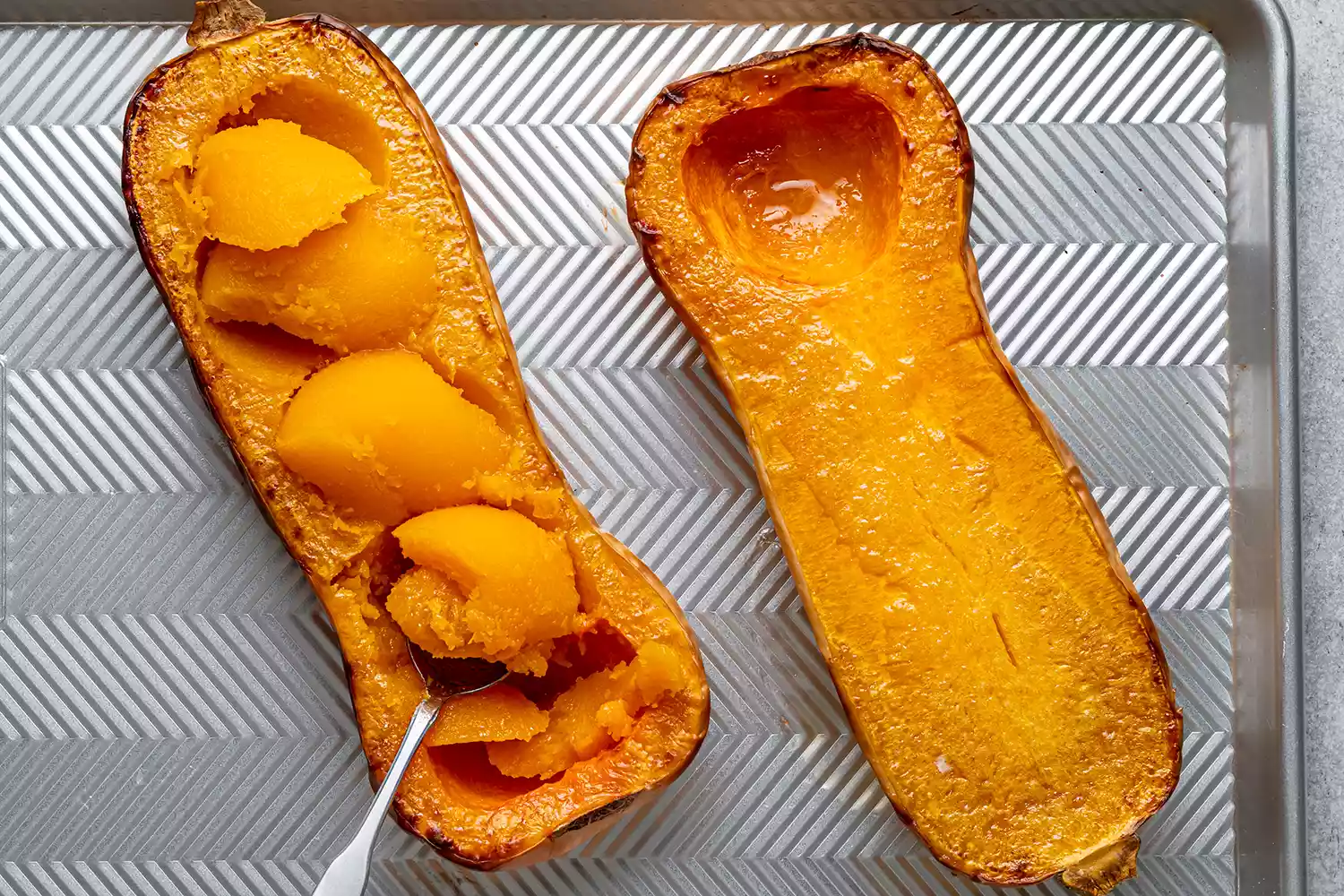 metades de abóbora assadas em uma assadeira