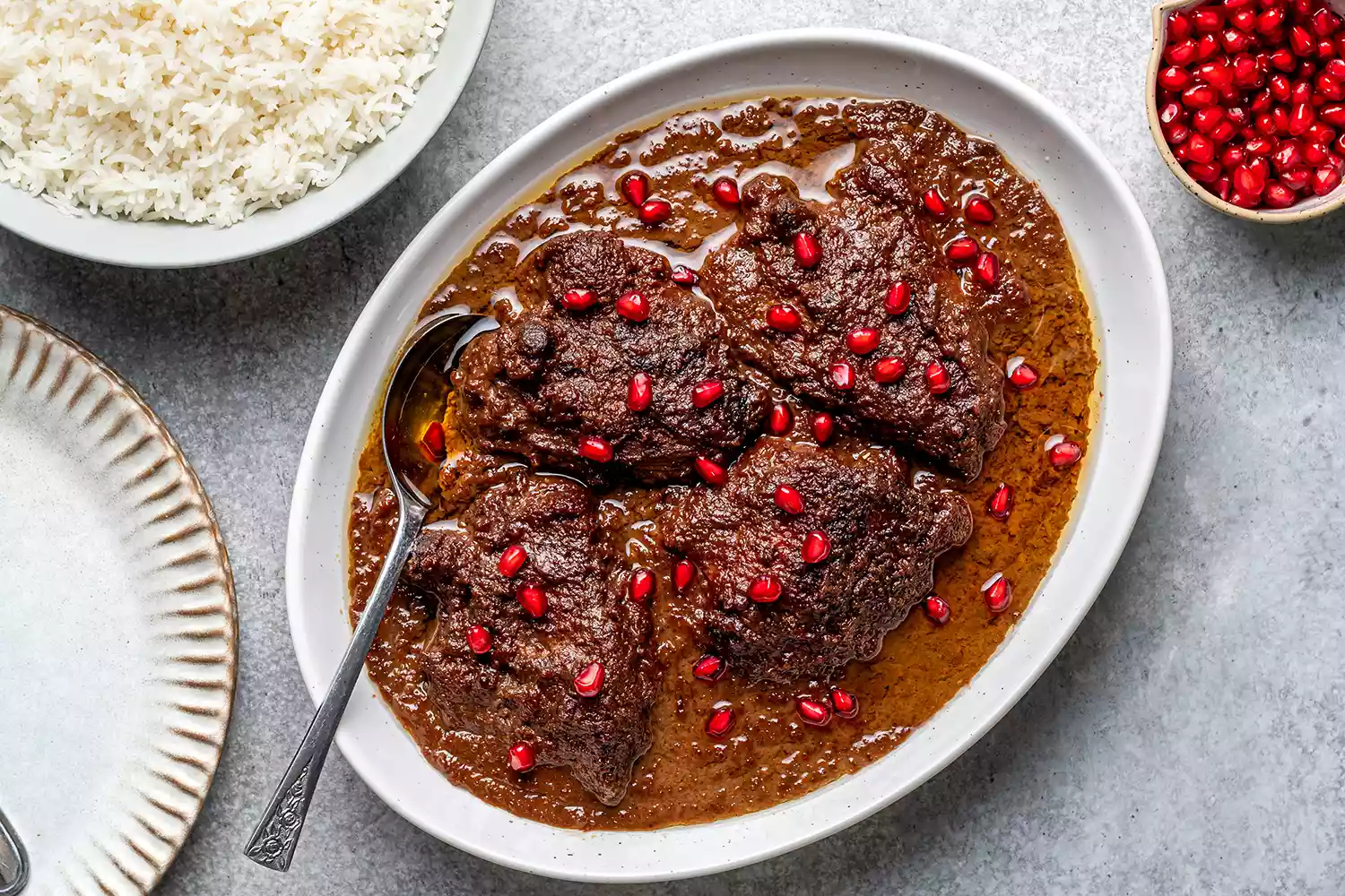 Fesenjan em uma travessa decorada com sementes de romã