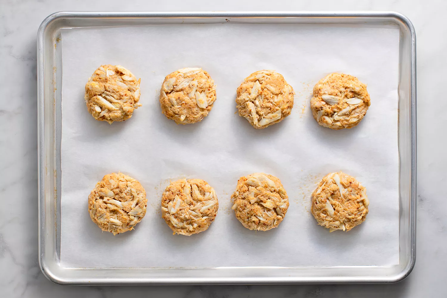 Bolinhos de caranguejo em uma assadeira forrada