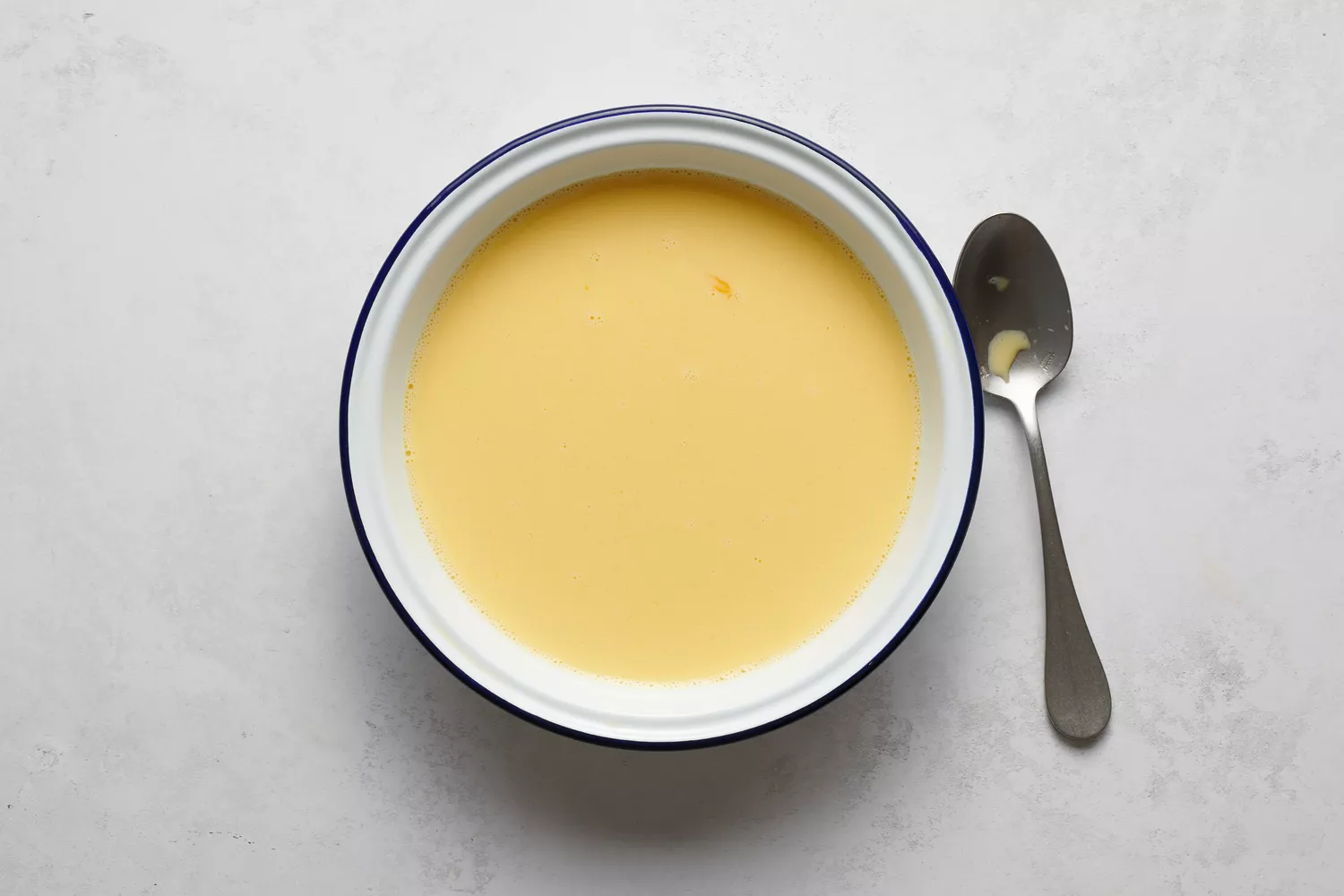 Uma tigela de ovos batidos, leite, açúcar e sal