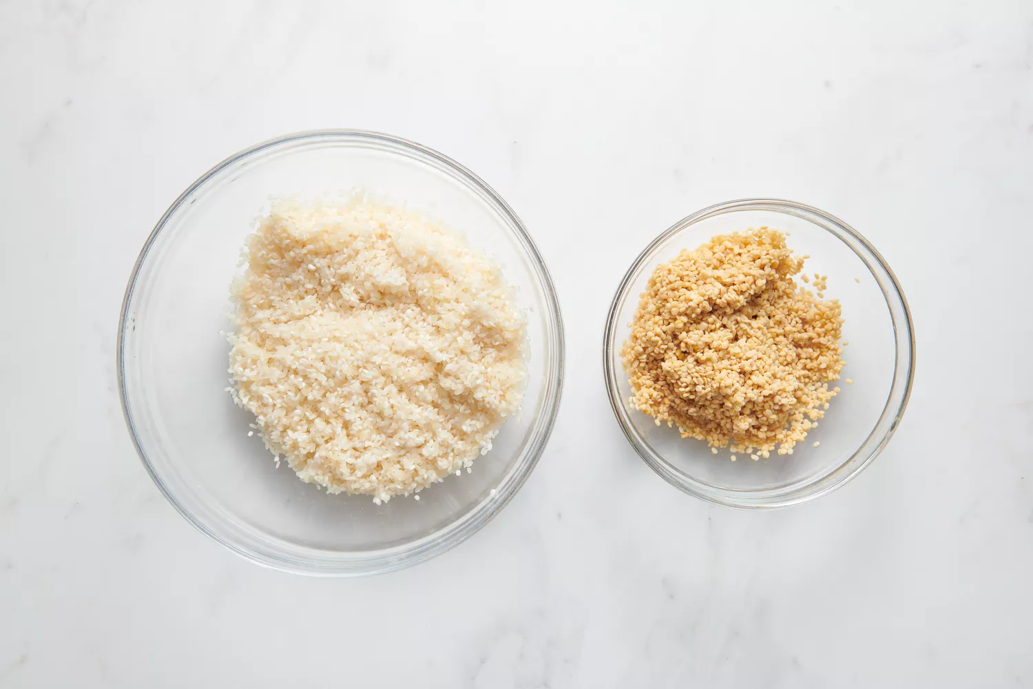 Uma tigela de vidro de Sona Masuri enxaguada e uma tigela de vidro de urad dal enxaguado