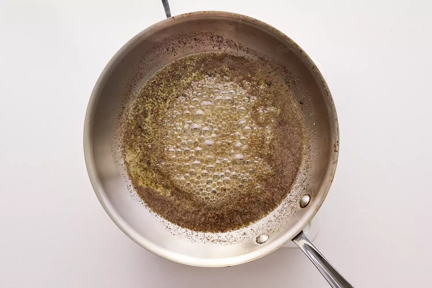 Manteiga aquecendo em uma panela de aço inoxidável.