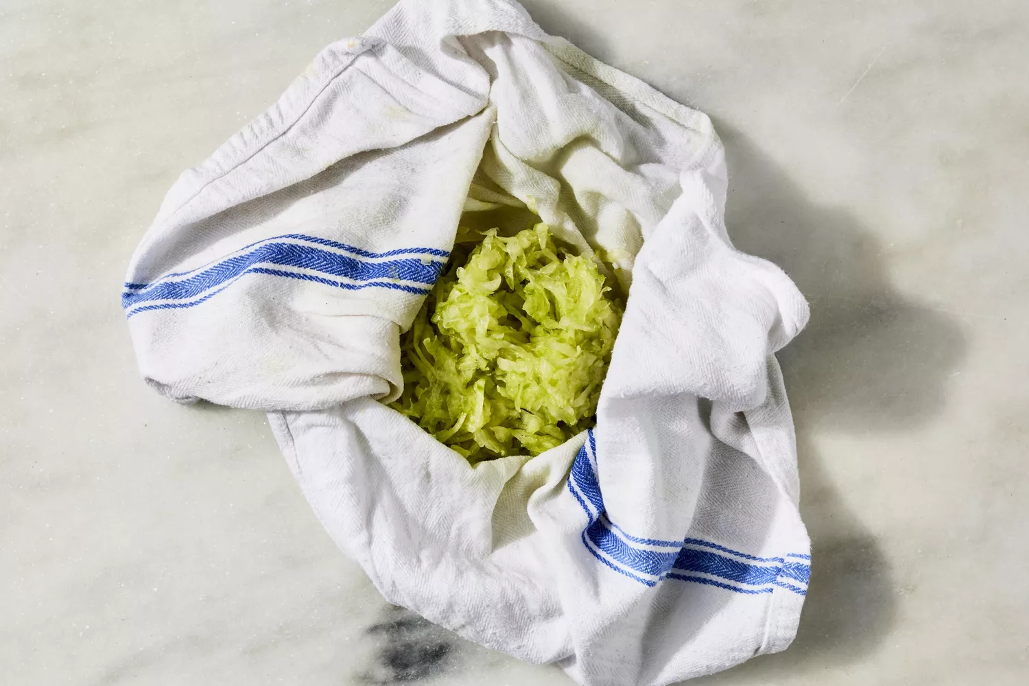 Peeled and grated cucumber in a clean kitchen towel