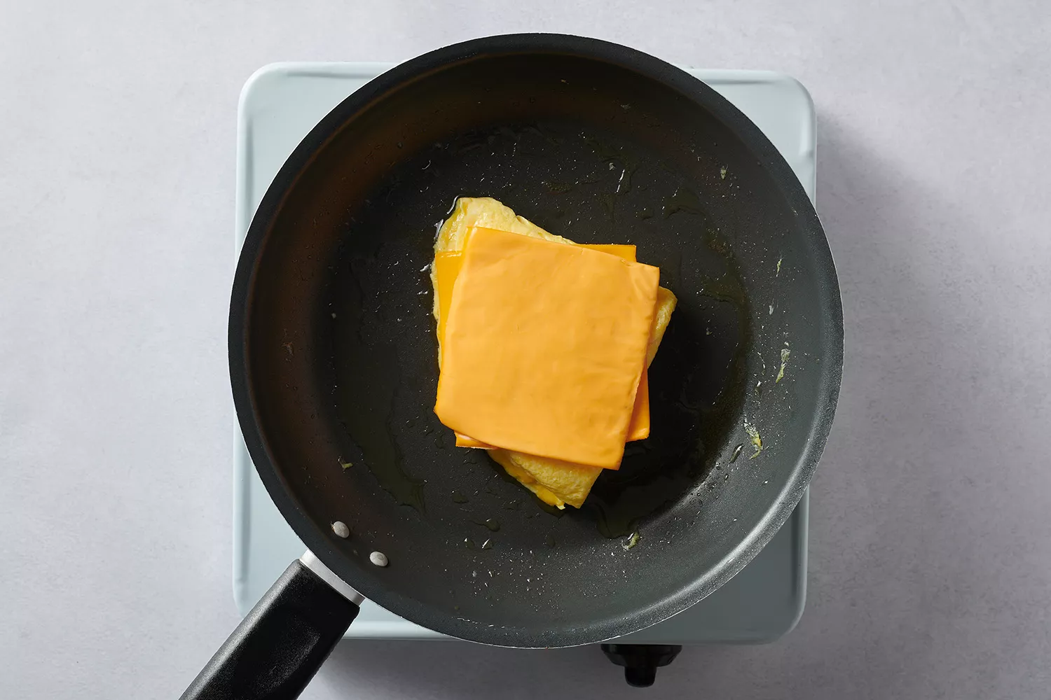 queijo sobre ovos na frigideira