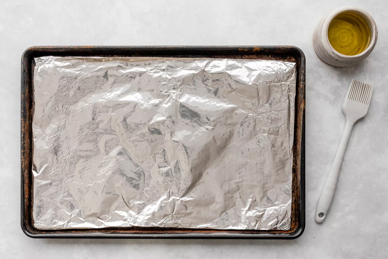 Assadeira forrada com papel alumínio e pincelada com óleo
