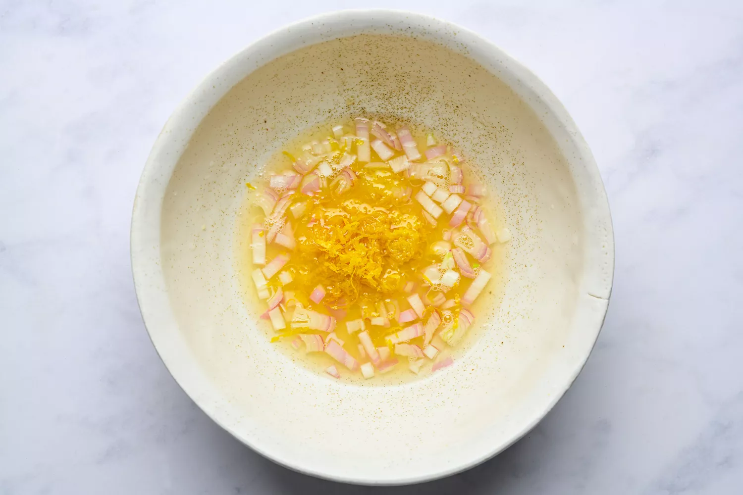 A bowl of diced shallot, lemon zest, and lemon juice