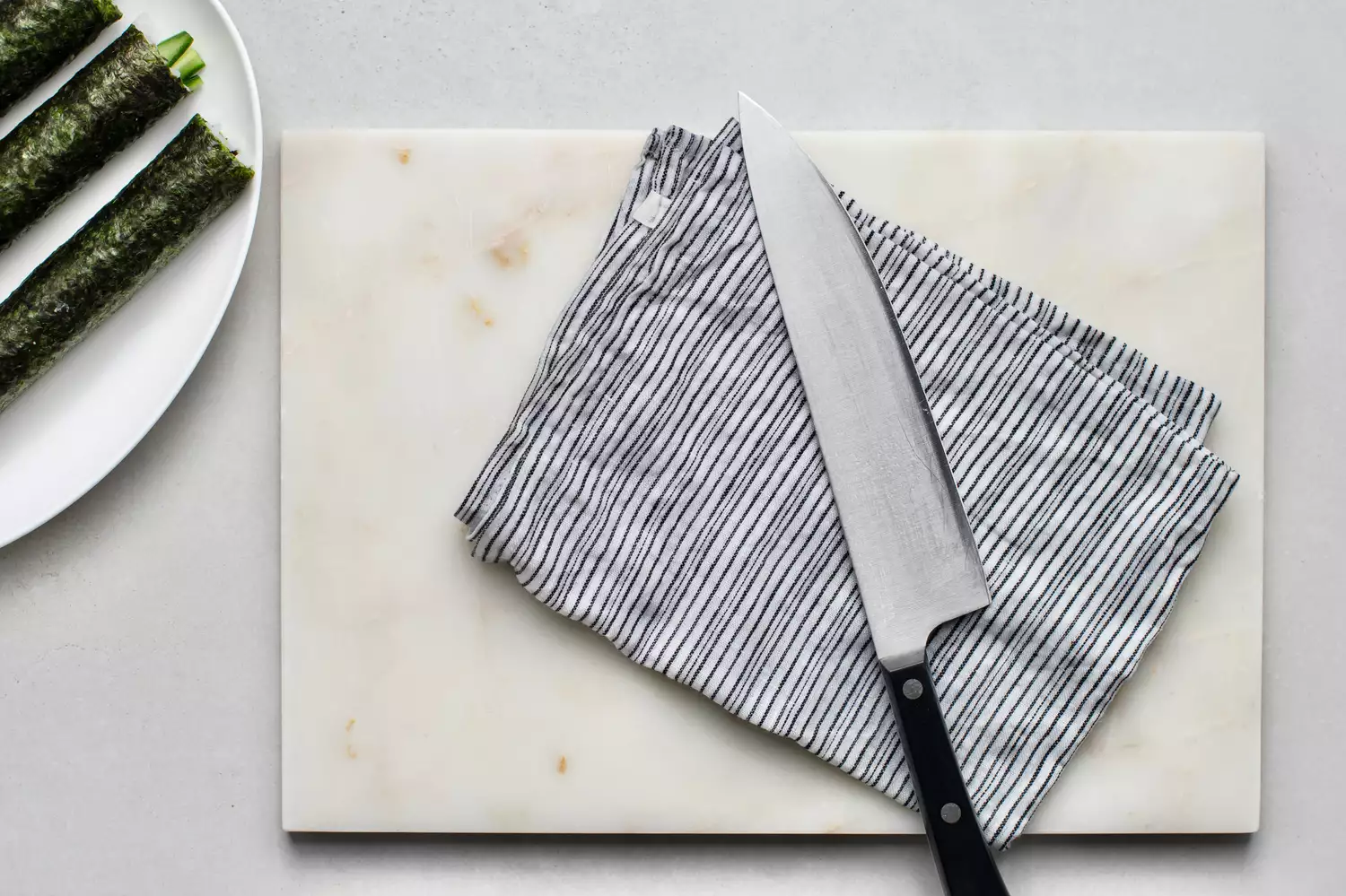 Faca e pano úmido sobre uma tábua de corte