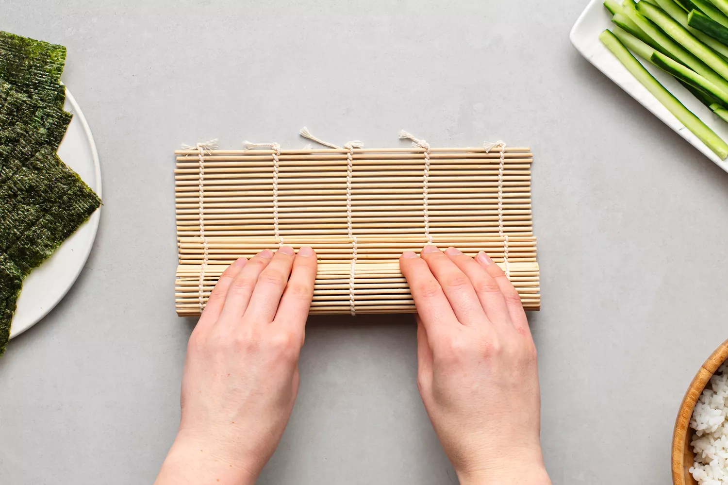Pressionar a esteira de bambu firmemente ao redor do rolo de sushi