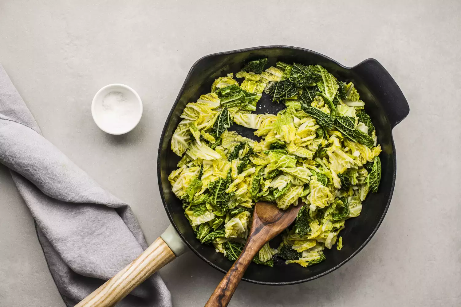 Panela com repolho cozido e pequeno recipiente de sal para tempero