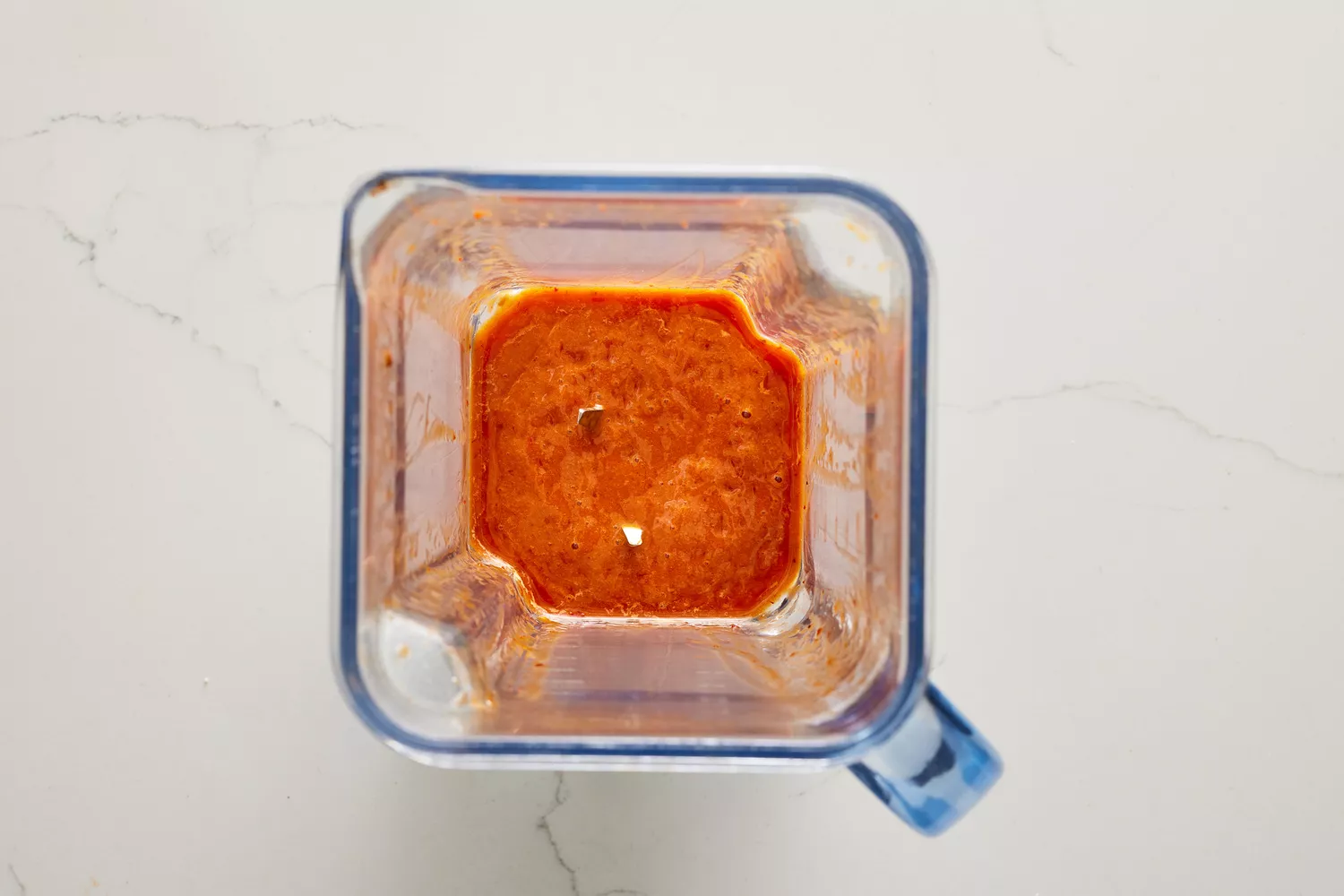 Um liquidificador com um molho de mel e pimenta