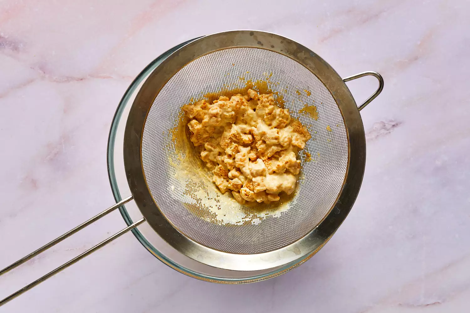 Uma peneira com cereal Cap'n Crunch embebido