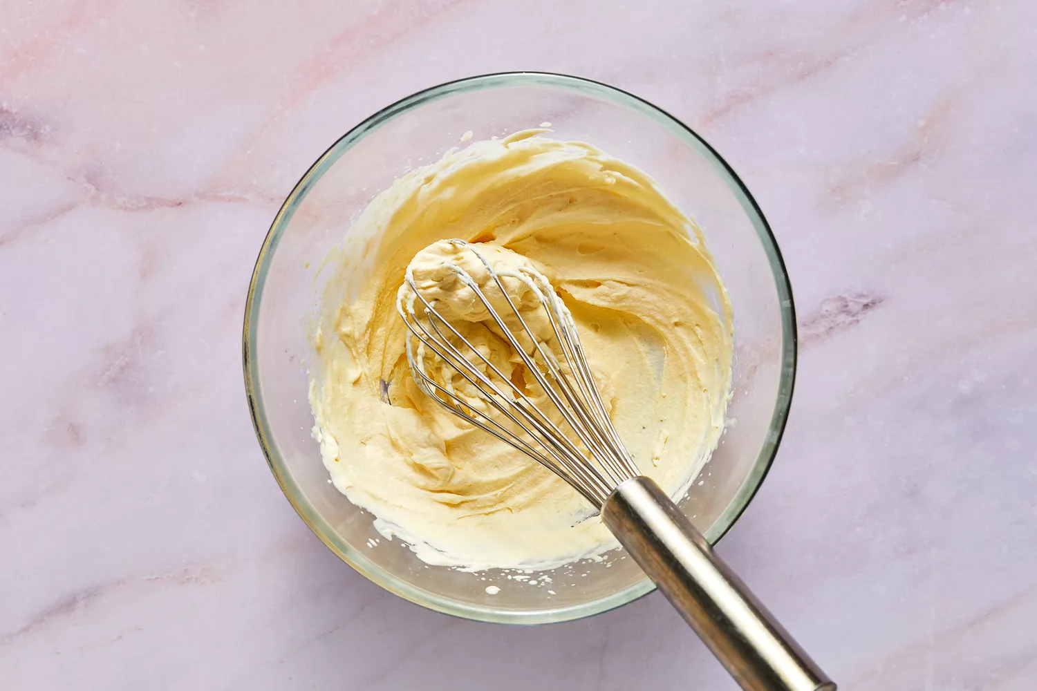 Uma tigela de chantilly com um batedor