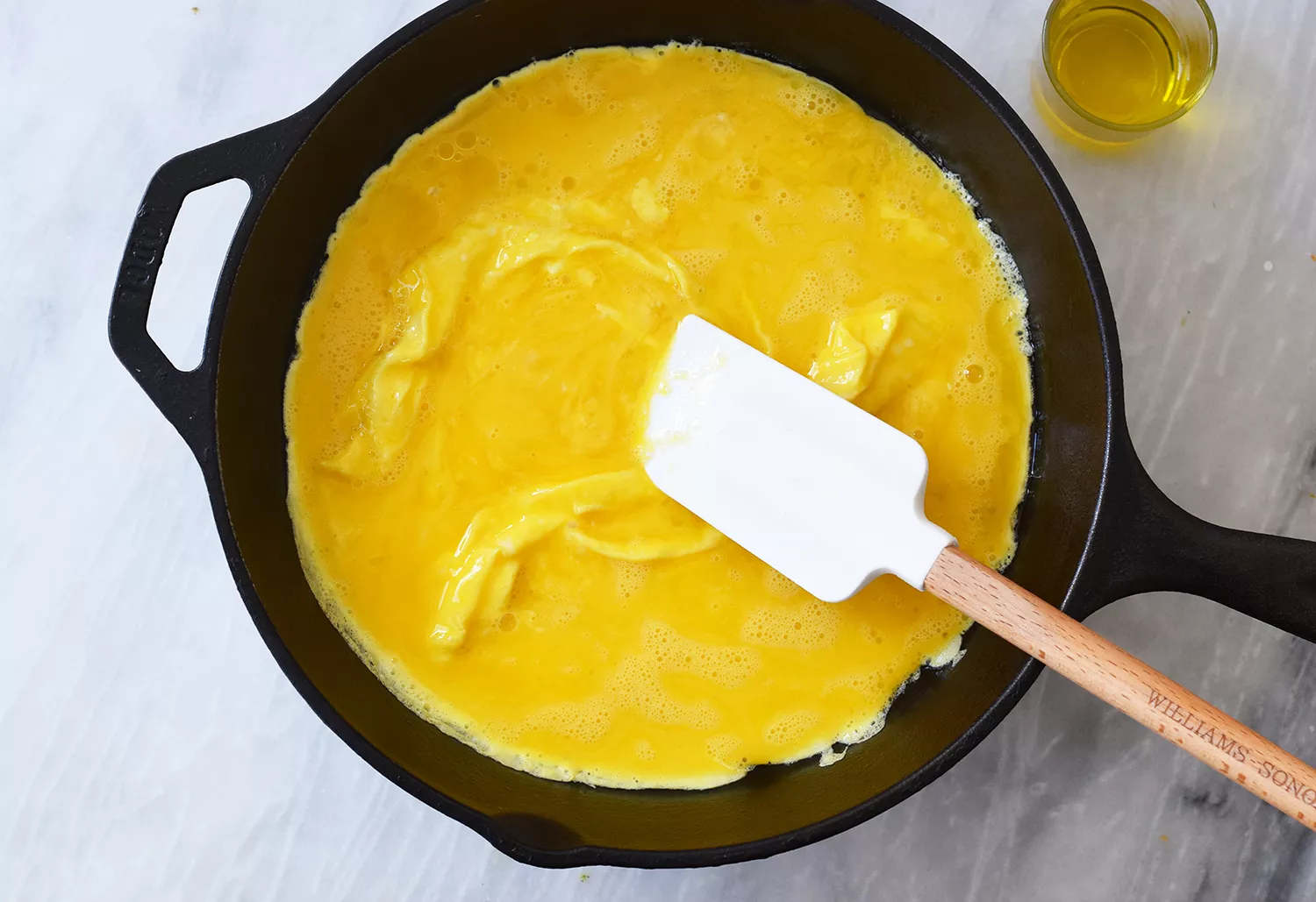 Ovos cozinhando em uma frigideira para omelete de frango