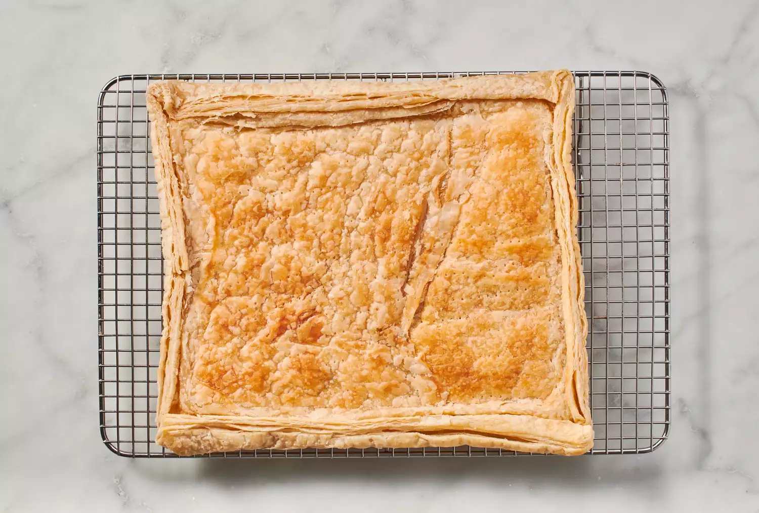Uma crosta de massa folhada parcialmente assada em uma grade