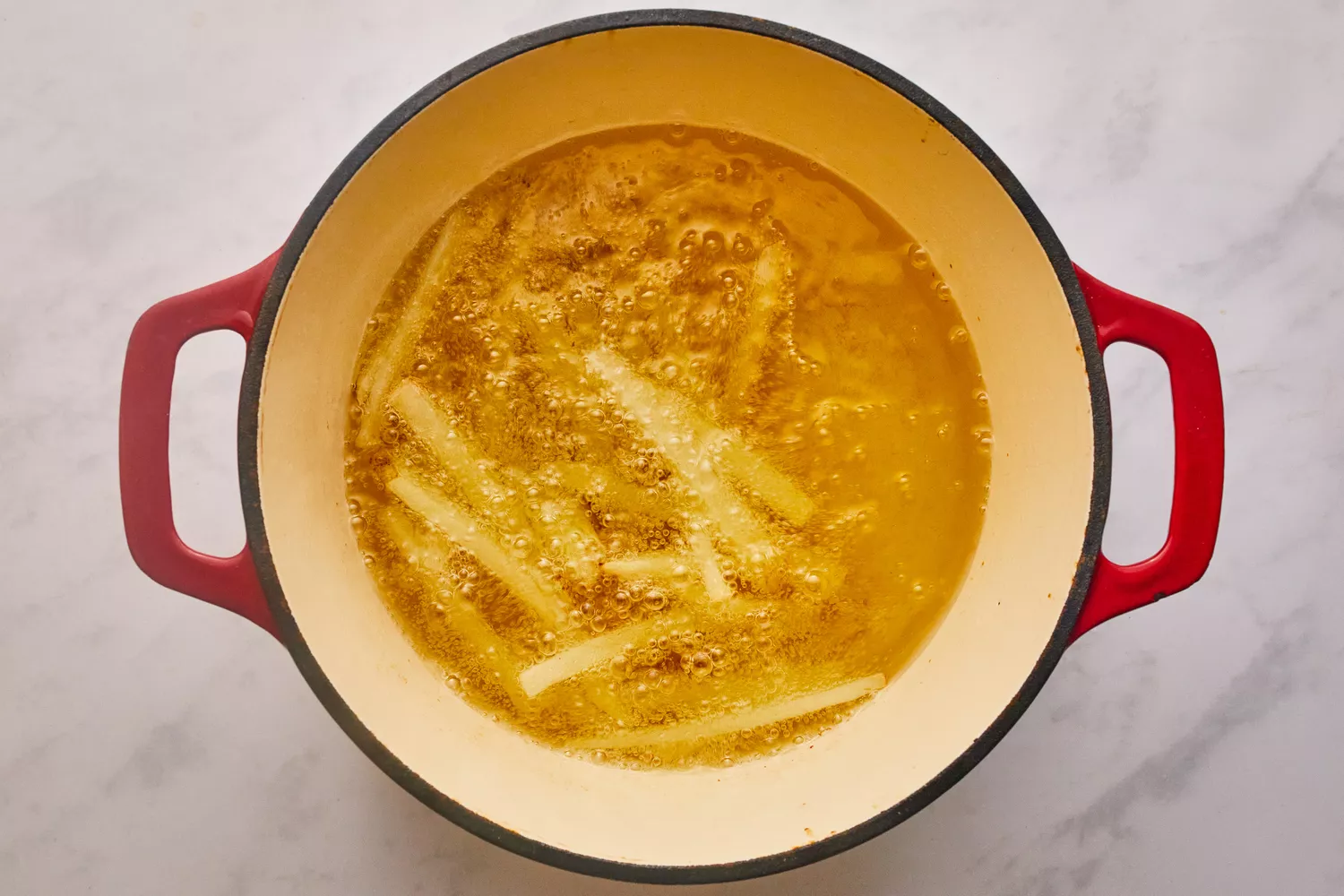 Fritando batatas em uma panela de óleo