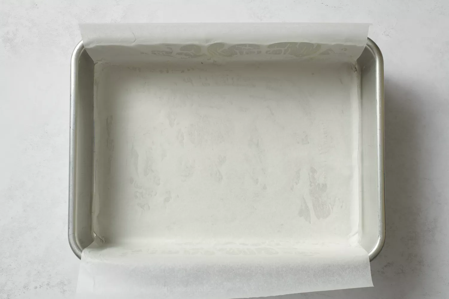 Uma assadeira de 9x13 polegadas forra com papel manteiga