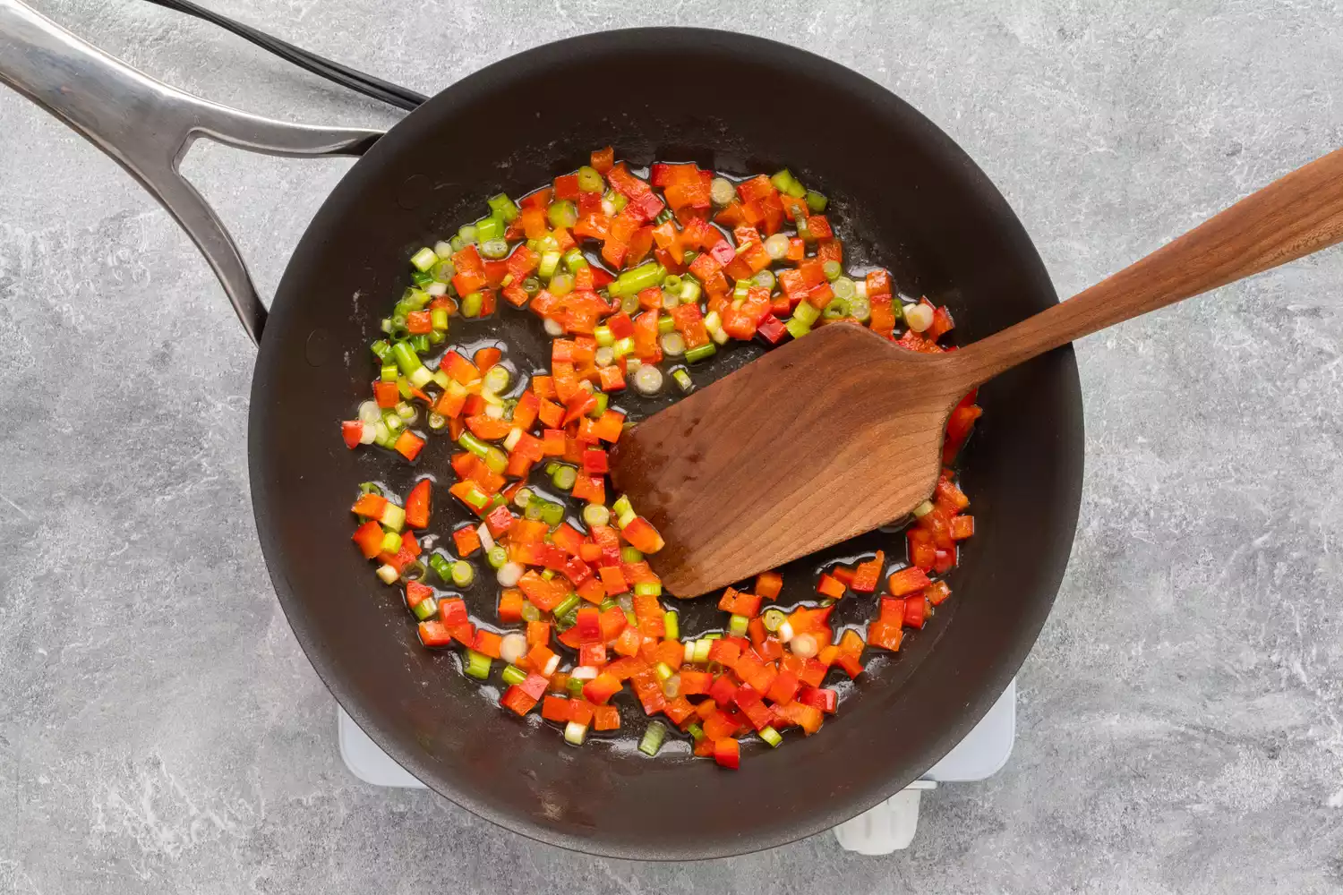 refogando cebolas verdes e pimentões
