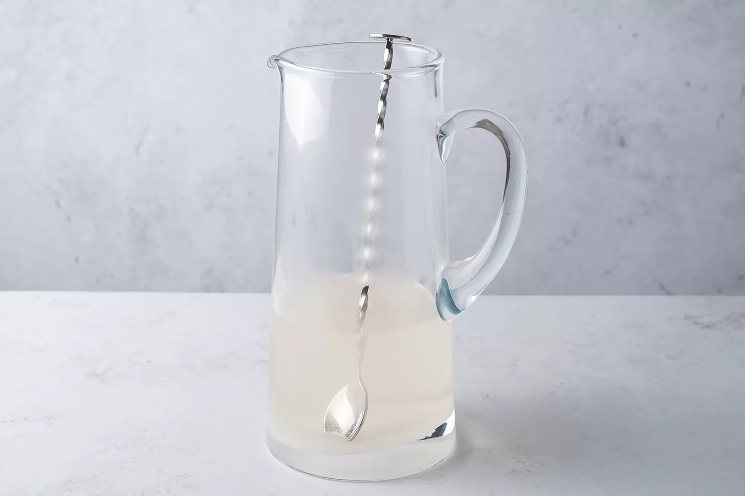 Mistura de açúcar e água em uma jarra com uma colher de mexer