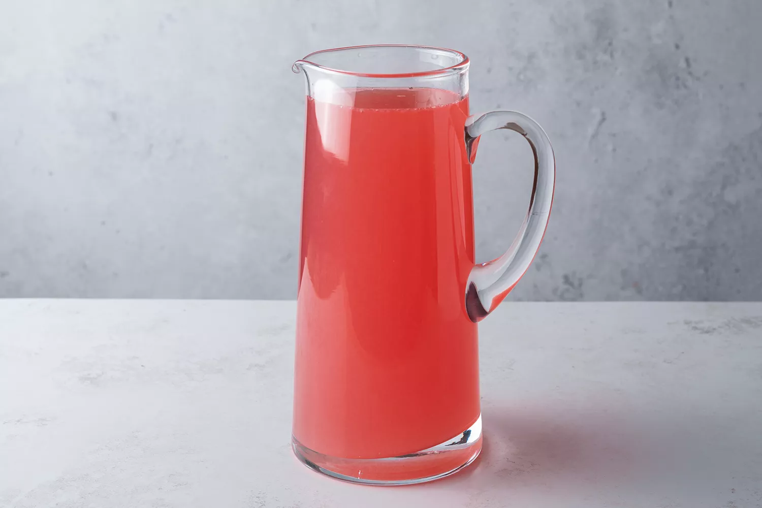 Suco de cranberry, suco de limão e água adicionados à mistura de açúcar em uma jarra