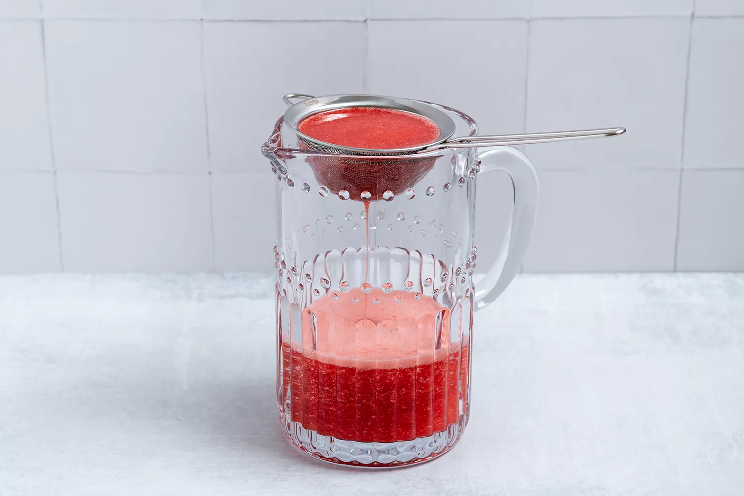 Mistura de morango coada em uma jarra de vidro