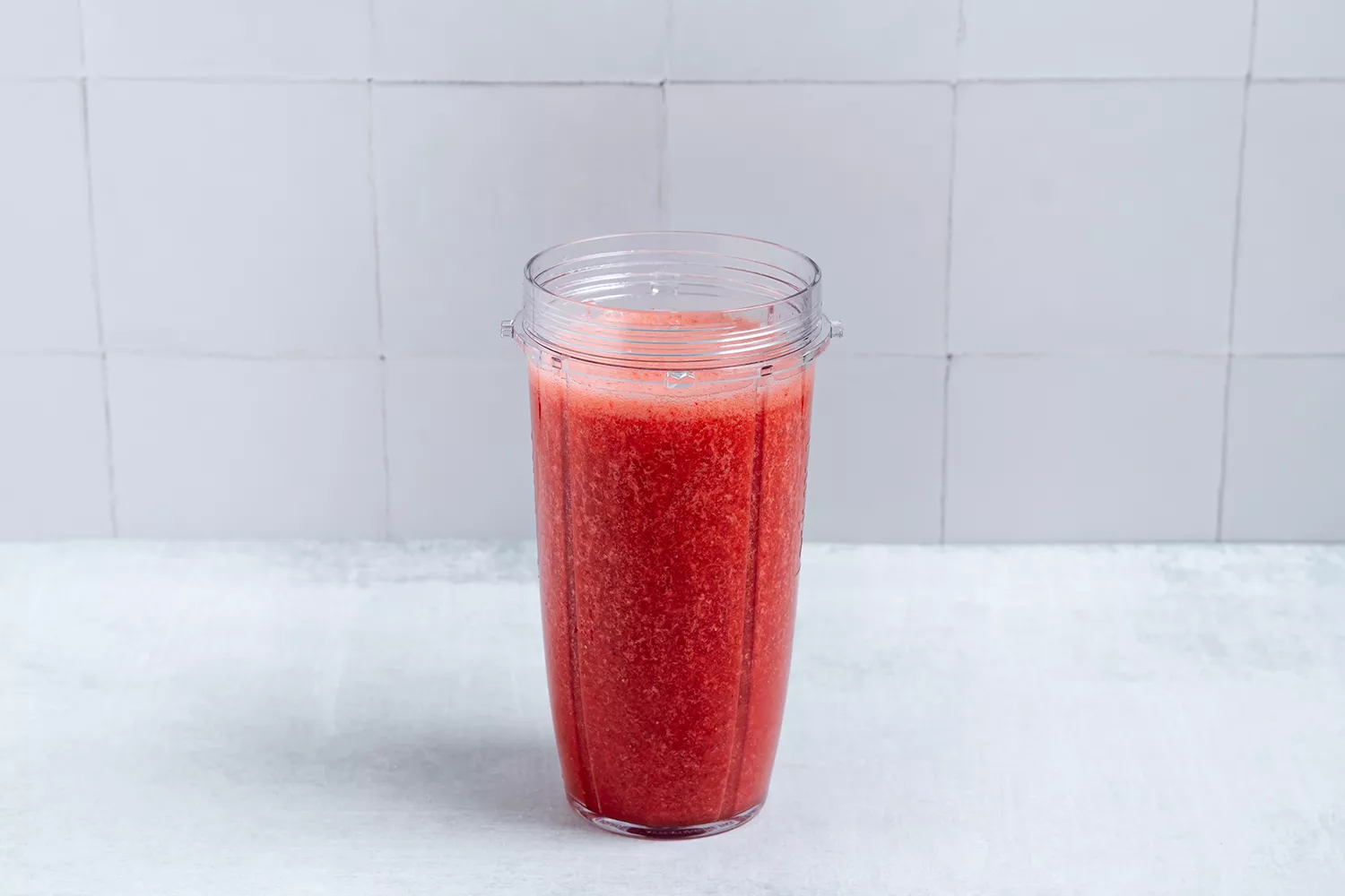 Mistura de morangos, água e açúcar em uma jarra de liquidificador