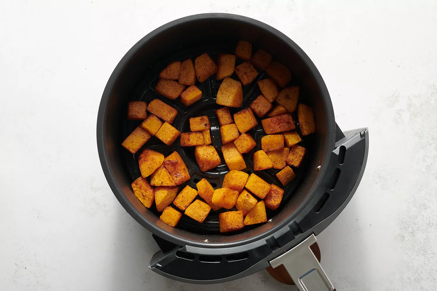 cubos de abóbora butternut em uma airfryer