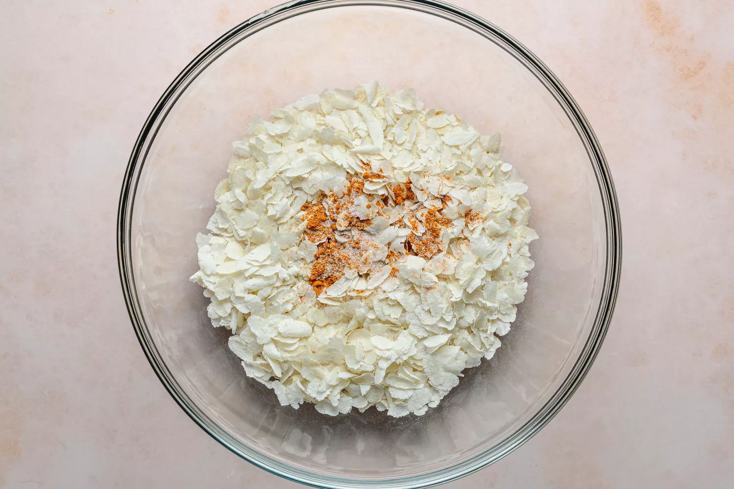 Uma tigela grande de poha torrado coberto com cúrcuma em pó e sal fino