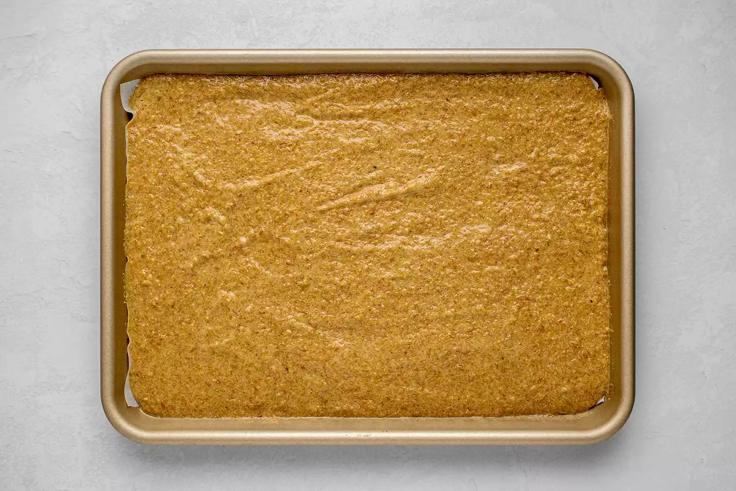 massa do pão de linhaça keto espalhada em uma assadeira