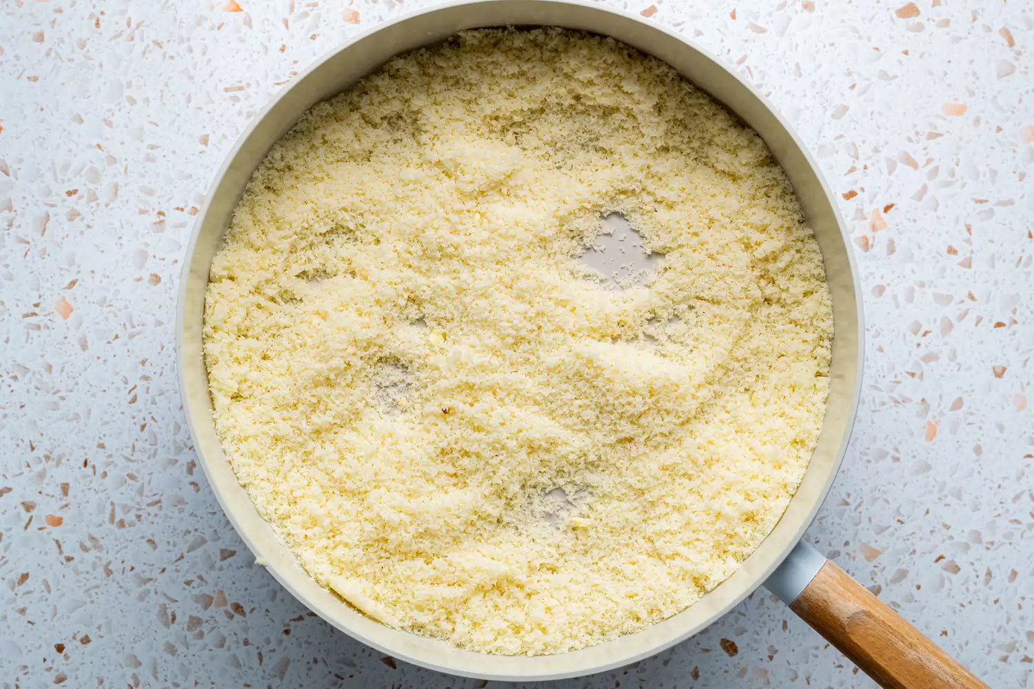 Uma panela com ghee, flocos de coco sem açúcar e leite em pó