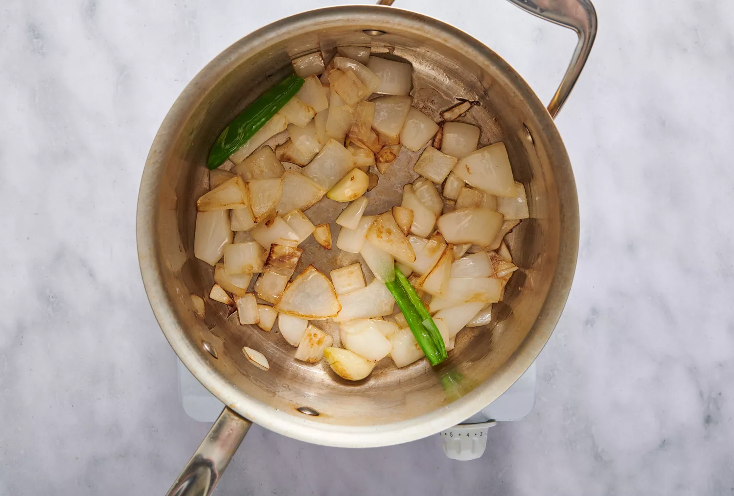 Uma panela com cebola picada, alho e pimenta serrano