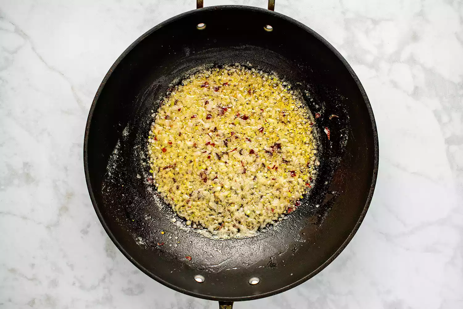 Cebola e pimenta vermelha esmagada na panela