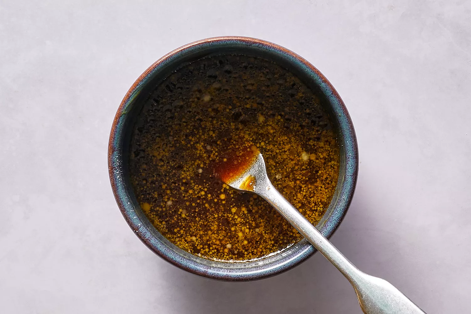 Caldo de galinha, molho de ostra, molho de soja, açúcar, óleo de gergelim e amido de milho em uma tigela com um garfo
