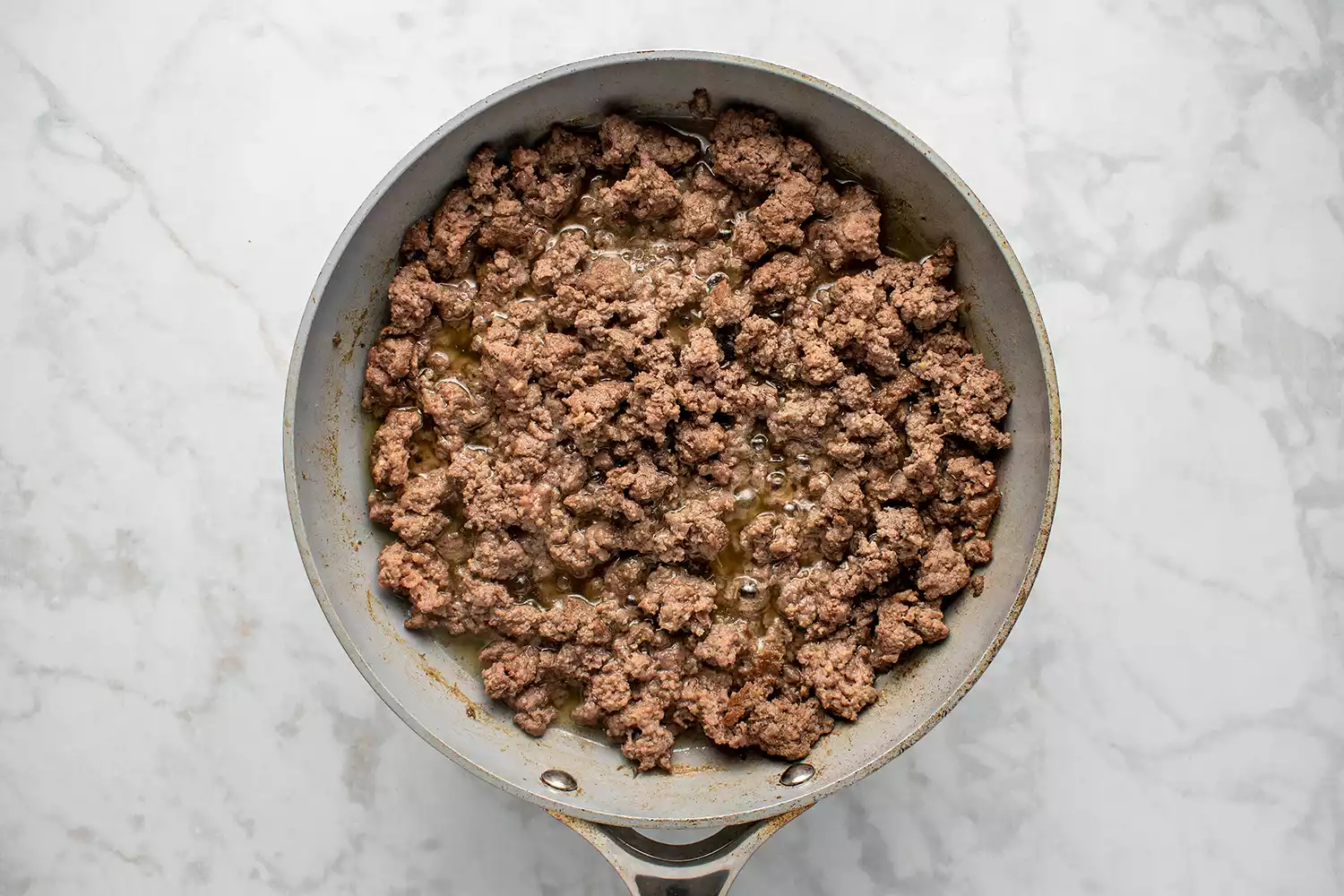 Carne moída levemente dourada em uma frigideira grande
