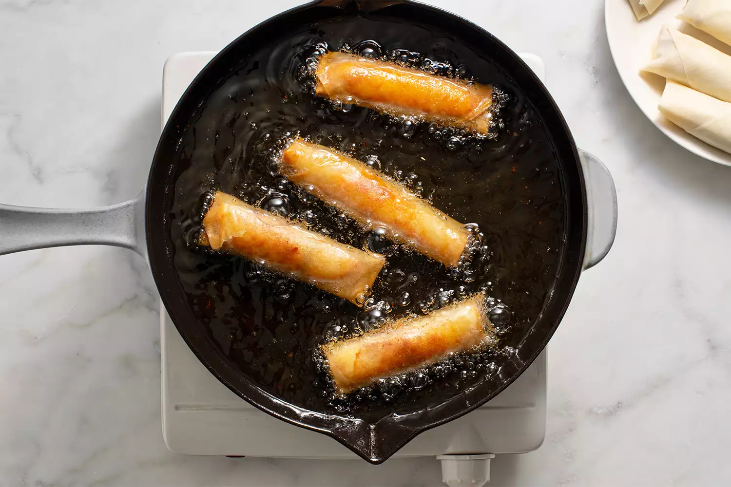 Egg Rolls de Philly Cheesesteak fritando em uma panela