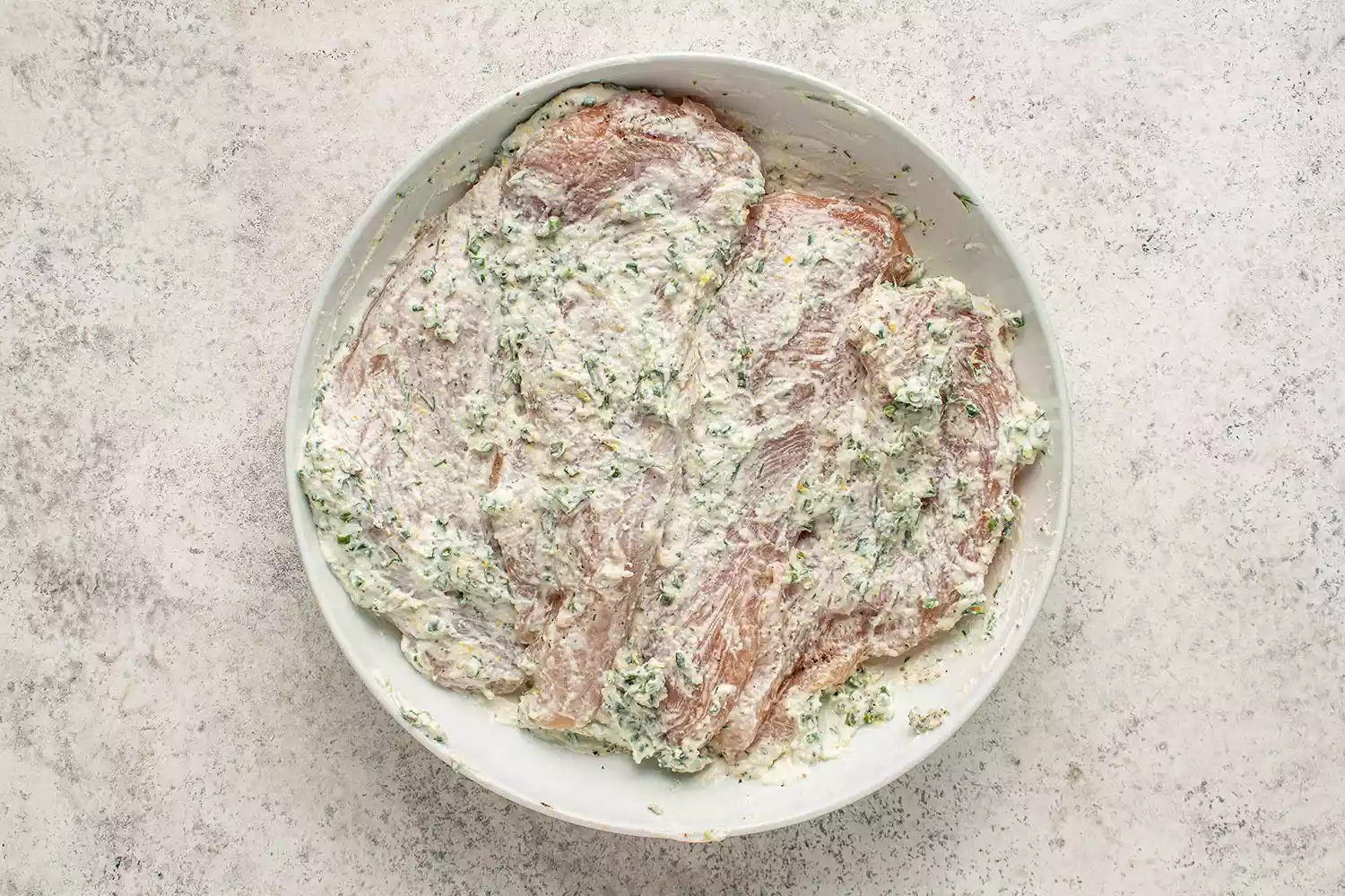 Frango coberto com a mistura de creme azedo em uma tigela