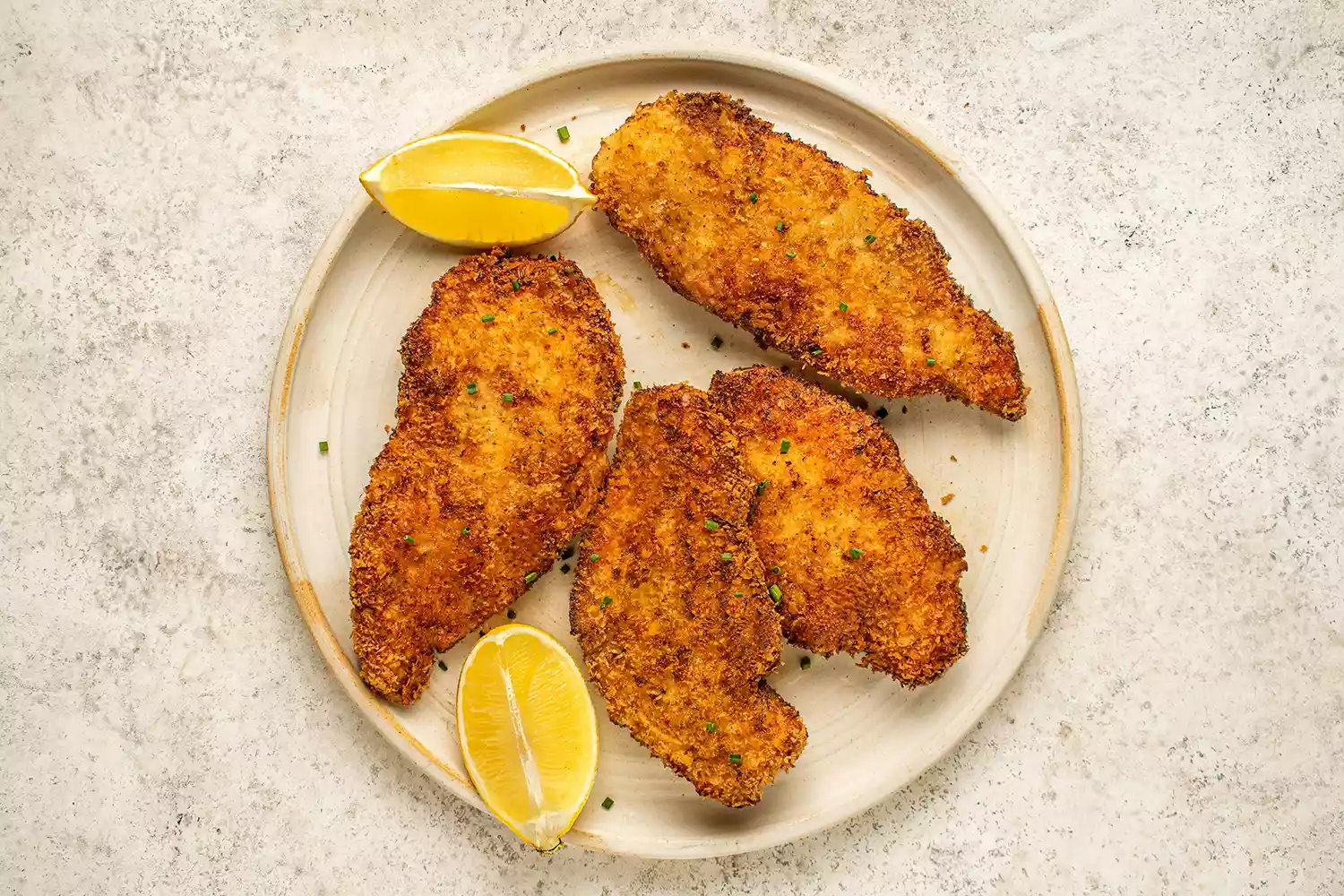 Frango com Creme Azedo e Cebolinha servido com fatias de limão em um prato