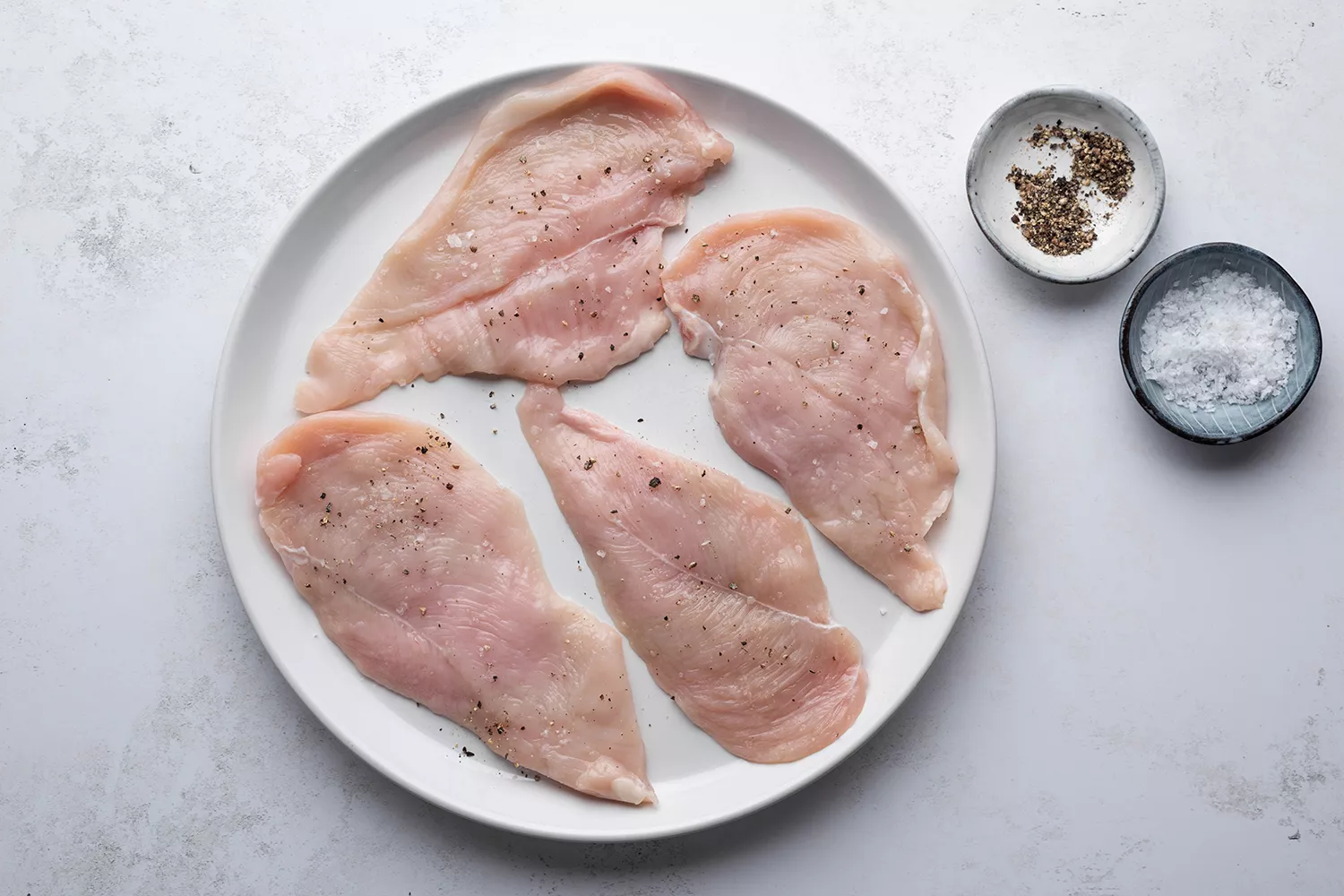 Frango temperado com sal e pimenta em um prato